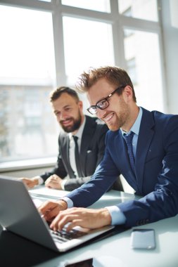 Dizüstü bilgisayarda tarama gülümseyen iş adamı