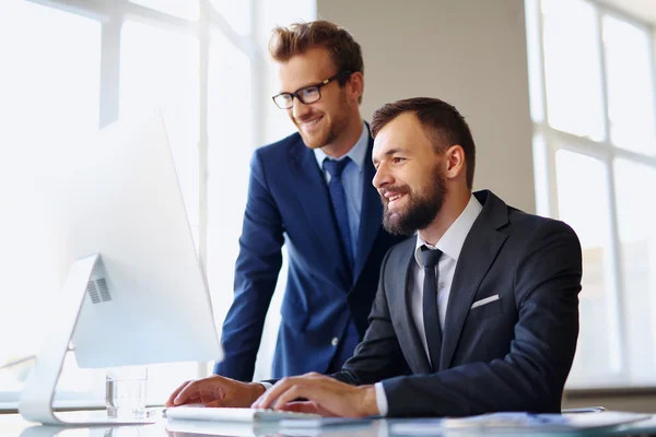 Businessmen using computer at meeting — Stock Photo, Image