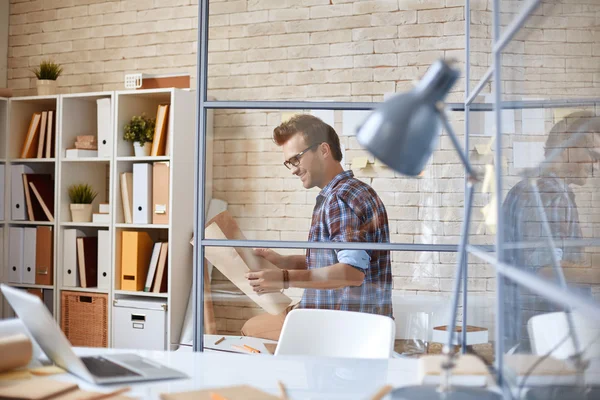 Arquiteto olhando para o modelo no escritório — Fotografia de Stock