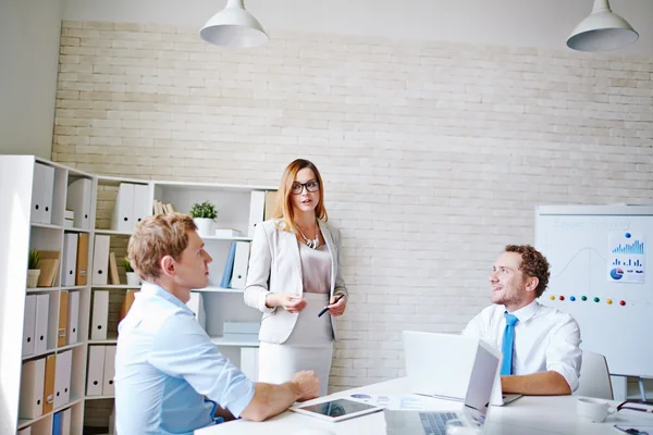 Empresaria explicando datos financieros a sus colegas —  Fotos de Stock