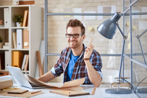 Zakenman met ontwerp op werkplek — Stockfoto