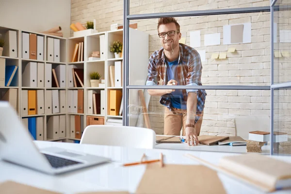 Werknemer op zoek naar grafiek op transparante bord — Stockfoto