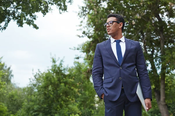 Hombre de negocios con touchpad de pie en el parque — Foto de Stock