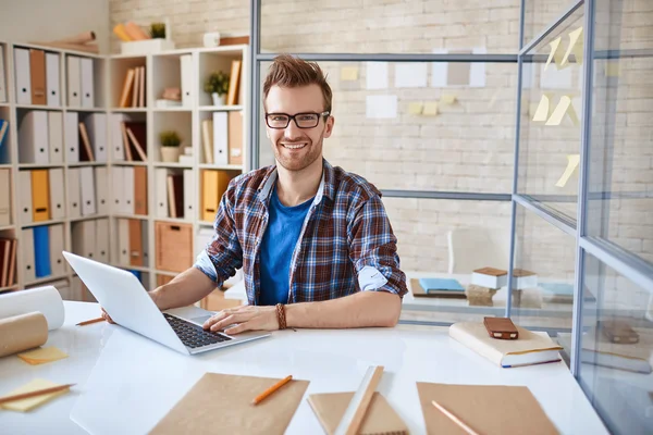 Homme d'affaires heureux assis sur le lieu de travail — Photo