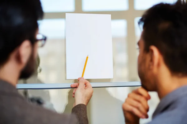 Homme d'affaires pointant vers le papier blanc — Photo