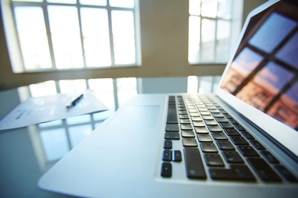 Mesa de escritório com laptop e planilha — Fotografia de Stock