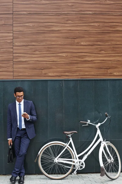 Uomo d'affari con valigetta utilizzando il cellulare — Foto Stock