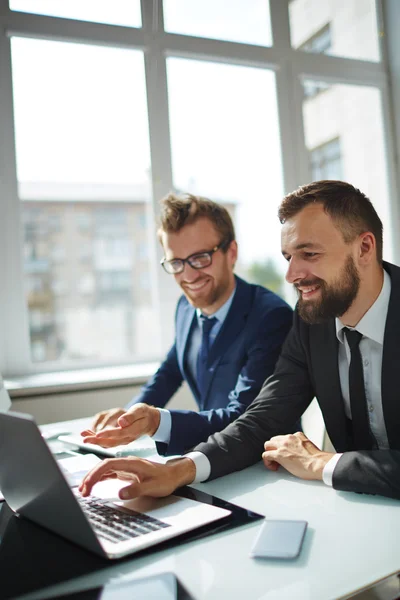 Empresário apontando para laptop com colega — Fotografia de Stock