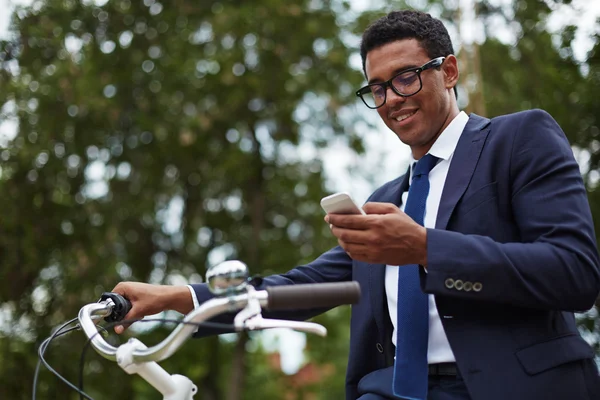 Uomo d'affari con cellulare e bicicletta — Foto Stock