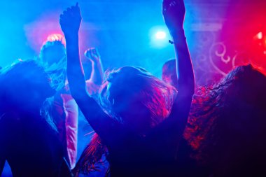 Gece kulübünde insanlar dans ediyor.