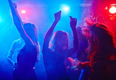 Gece kulübünde insanlar dans ediyor.