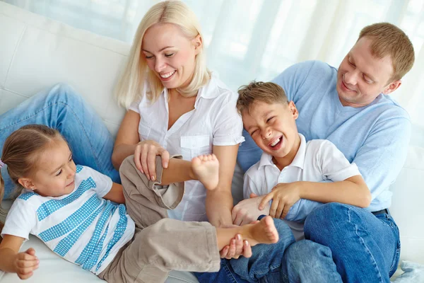 Rodzina bawiąca się na kanapie — Zdjęcie stockowe