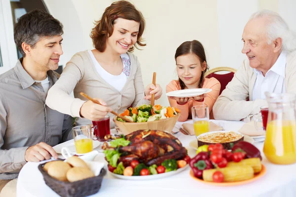 Mulher dando salada para sua filha — Fotografia de Stock