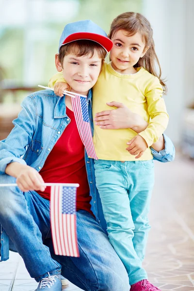 Ragazzo e ragazza con bandiere americane — Foto Stock