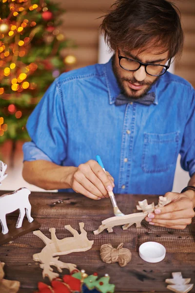 Man painting wooden toy deer — Stock Photo, Image