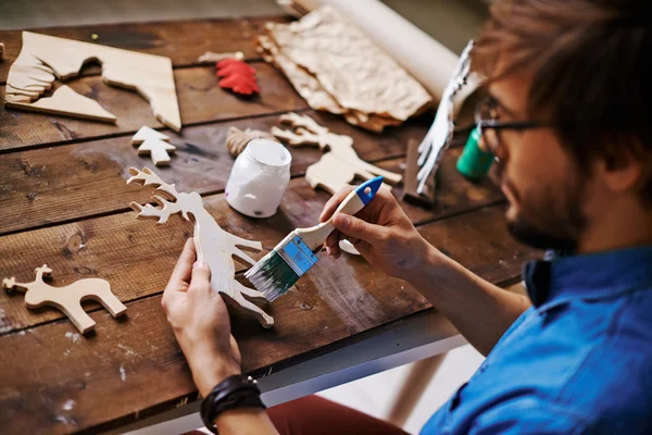 Artesano con pintura al pincel ciervo de madera — Foto de Stock