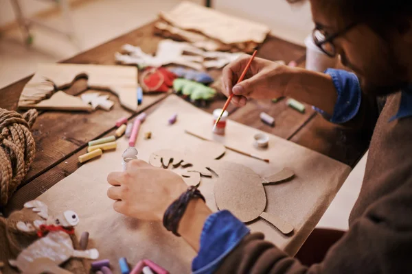 Craftsman with paintbrush painting paper deer — Stock Photo, Image