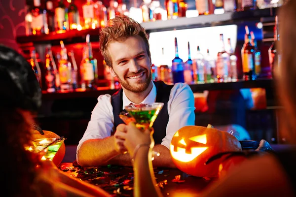 Barman clinking glasses with clients — Stock Photo, Image