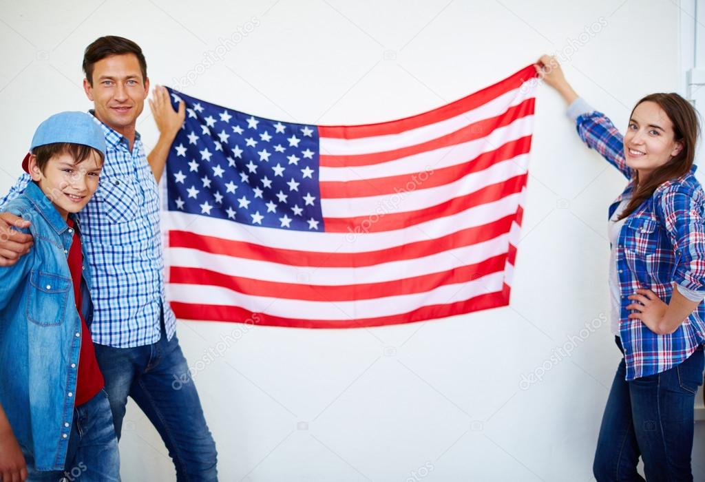 Family hanging USA flag on wall