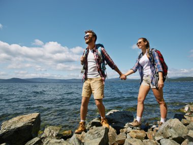 Deniz kenarında kayaların üzerinde yürüme Çift