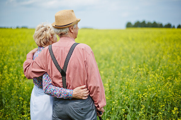пожилая пара наслаждается летним днем на лугу
