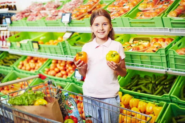 Dívka, volba papriky v supermarketu — Stock fotografie