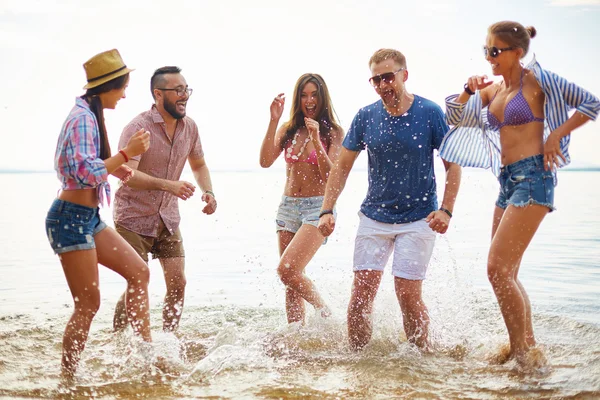 Freunde, die Wasser spritzen und lachen — Stockfoto