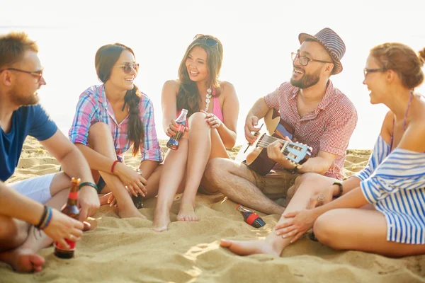 Vriendelijke bedrijf met drankjes en gitaar — Stockfoto