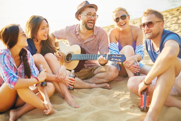 Freunde mit Getränken und Gitarre am Wasser — Stockfoto