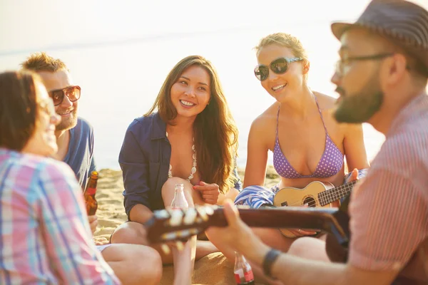 Amigos com guitarra e cerveja na praia — Fotografia de Stock