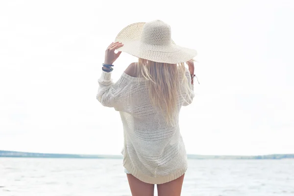 Donna in cappello e pullover bianco in riva al mare — Foto Stock