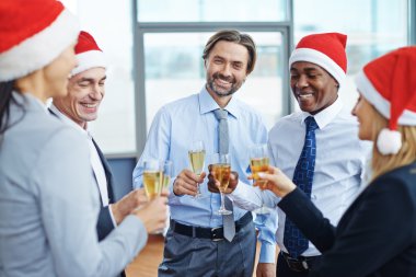 meslektaşları partide toasting Santa kapaklar