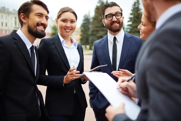 Happy businesswoman among busy colleagues — Stock Photo, Image