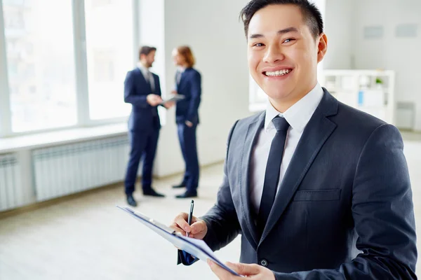 Businessman with pen and clipboard — Stock Photo, Image