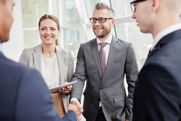 Colleagues greeting business partner — Stock Photo, Image