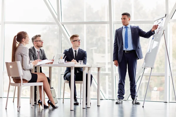 Hombre de negocios de pie junto a la pizarra y explicando los datos —  Fotos de Stock