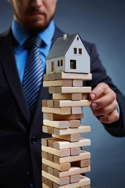 Empresário tocando torre de pequenos blocos — Fotografia de Stock