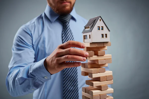Empresario tocando torre de bloques pequeños — Foto de Stock