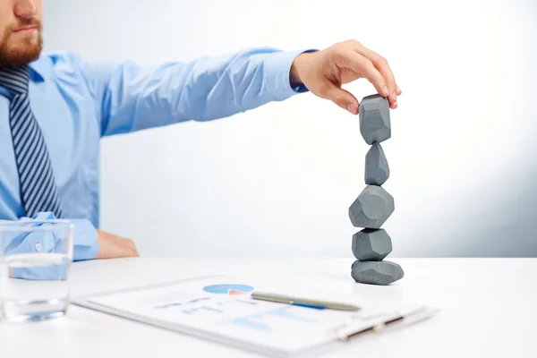 Torre de construcción hombre de negocios de piedras grises — Foto de Stock