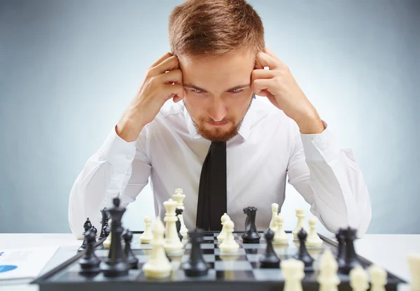 Hombre de negocios mirando el tablero de ajedrez —  Fotos de Stock