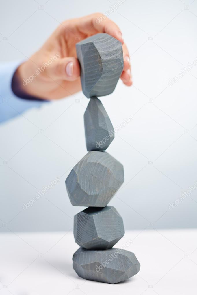 Businessman building tower from stones