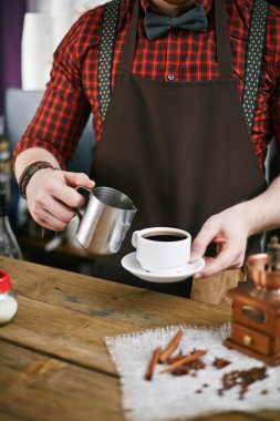 barista holding Kupası ve çelik kupa