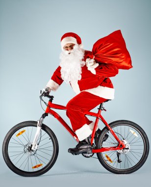 Noel Baba bisiklet üzerinde kırmızı çuval ile