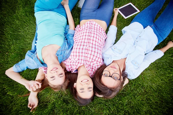 Teen girls lying on green grass — Stock Photo, Image
