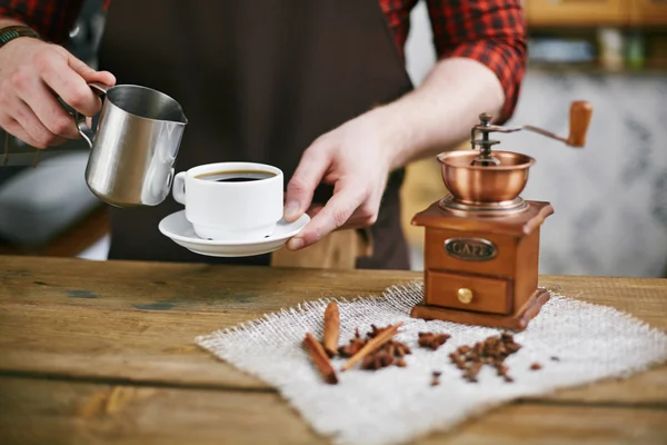 Barista houden cup en stalen mok — Stockfoto