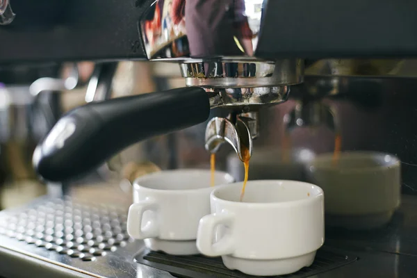 Espresso pouring in cups from coffee machine — Stock Photo, Image