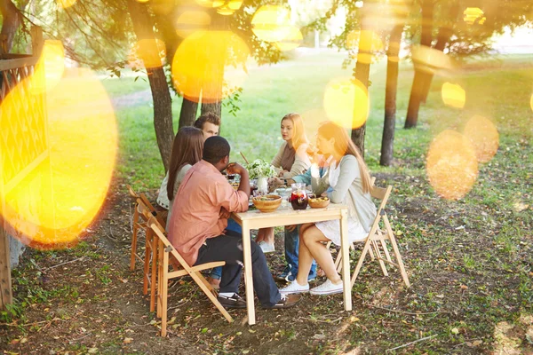 Vrienden zitten door Thanksgiving tabel — Stockfoto