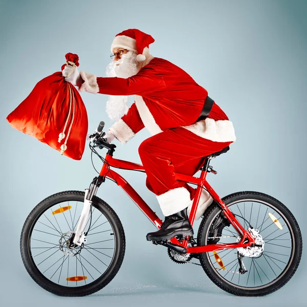 Kerstman met rode zak op fiets — Stockfoto