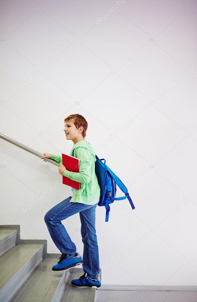 schoolboy with backpack going upstairs
