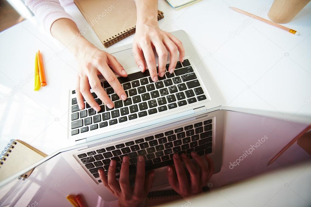 student pressing keys of laptop